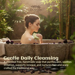 A woman sits in a stone bath surrounded by greenery, holding a bar of soap. The image includes the brand name 'Dr Ancient' at the top and promotional text about gentle daily cleansing at the bottom.