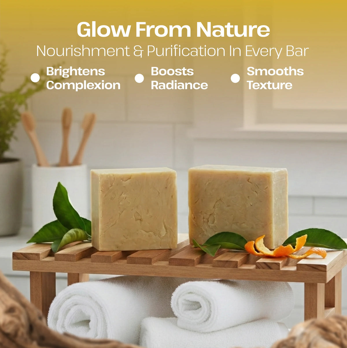 Two rectangular bars of pale yellow soap displayed on a small wooden stand in a spa-like setting, with white towels underneath and decorative leaves and orange peel around them. Text at the top reads 'Glow From Nature' and 'Nourishment & Purification In Every Bar' with bullet points about brightening complexion, boosting radiance, and smoothing texture.