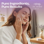 A woman in a white robe applies a white facial cleanser to her face in a bright, softly lit bathroom setting. Large text at the top reads 'Pure Ingredients, Pure Results' with the Dr.