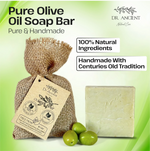 A bar of Dr. Ancient Pure Olive Oil Soap shown with a burlap bag, olive branch tag, and three green olives on a light green background with promotional text.