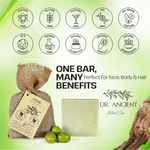 Dr. Ancient natural soap bar with packaging and green olives on a light green background