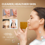 A woman in profile holds a square bar of golden-yellow soap against a warm beige background with promotional text for Dr. Ancient Natural Care.