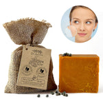 A bar of orange-brown Dr. Aishwarya Bhatnagar Neem Soap next to its brown burlap packaging bag with a paper tag, on a white background with a circular inset showing a woman's face.