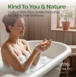 A woman in a bubble bath holds an orange bar soap, with text reading 'Kind To You & Nature' and 'Crafted With Olive & Wild Pistachio For Skin & Hair Wellness.' The brand 'DR.