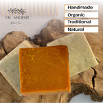 Three rectangular bars of natural soap displayed on a rustic wood slice background, with the brand name Dr. Ancient Natural Care in the top left and text labels reading Handmade, Organic, Traditional, and Natural on the right.