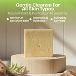 A pale yellow rectangular soap bar displayed upright on a round wooden pedestal, with marketing text above reading 'Gentle Cleanse For All Skin Types' and bullet points about nourishment, hydration, and comfort.