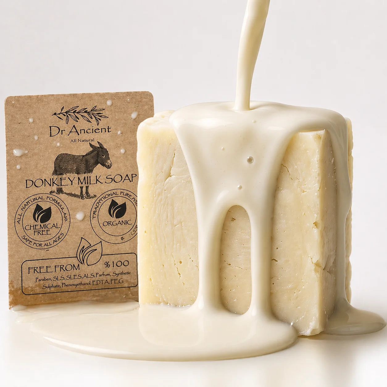 A bar of Dr. Ancient Donkey Milk Soap stands next to its kraft paper packaging, with creamy off-white liquid being poured over it, creating a glossy drip effect on a clean white background.