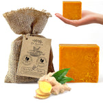 Turmeric soap with a burlap bag, ginger root, and leaves on a white background.