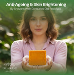 Woman holding a yellow bar of soap with greenery in the background, promoting anti-ageing and skin brightening products.
